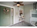 Cozy screened front porch with ceiling fan and seating area at 215 Chula Vista Ave, The Villages, FL 32159