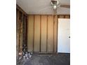 Unfinished room with exposed studs, debris, and a ceiling fan, ready for renovation at 220 E Woodward Ave, Eustis, FL 32726