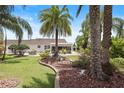 Expansive backyard featuring a covered patio and lush tropical landscaping at 2312 Nackman Pl, The Villages, FL 32162