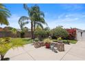 Picturesque backyard with a charming patio area, lovely plantings, and tropical landscaping at 2312 Nackman Pl, The Villages, FL 32162
