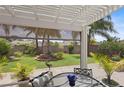 Covered patio area with stylish outdoor furniture, and a view of the meticulously landscaped yard at 2312 Nackman Pl, The Villages, FL 32162