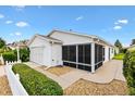 Rear exterior view of home with screened in porch and manicured shrubs at 2317 Whisper St, The Villages, FL 32162