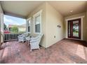 Charming covered front porch with seating, offering a relaxing outdoor space near the main entrance at 243 Bayou Bend Rd, Groveland, FL 34736