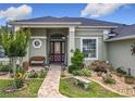 Charming home exterior with beautiful landscaping and a brick walkway to the front door at 25222 Laurel Valley Rd, Leesburg, FL 34748