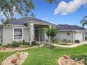Inviting home exterior with lush green lawn, mature trees and well-maintained landscaping at 25222 Laurel Valley Rd, Leesburg, FL 34748