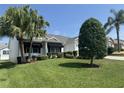 Charming single-story home with lush landscaping, mature trees, and black awnings at 2530 Hanlon Ter, The Villages, FL 32162