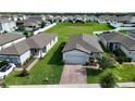 This aerial view showcases a home with a brick driveway, lush lawn, and flowering tree at 29810 Anahid Dr, Leesburg, FL 34748