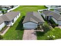 Aerial view of a one-story home showing a brick-paved driveway and well-kept landscaping at 29810 Anahid Dr, Leesburg, FL 34748