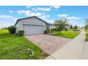 A lovely home with a brick driveway and beautiful tree, showcasing a well-kept lawn at 29810 Anahid Dr, Leesburg, FL 34748