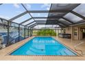 Screened in pool with a jacuzzi, waterfall feature, and ample space for relaxation at 3097 Bureau Path, The Villages, FL 32163