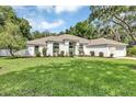 Lush green lawn complements this home's architecture, creating a welcoming and picturesque setting at 34231 Shadewood Cir, Leesburg, FL 34788