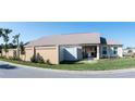 Stylish home exterior featuring a well-maintained lawn, patio with outdoor seating, and a neutral color scheme at 3466 Smedley Rd, The Villages, FL 32163