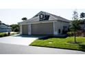Residential two-car garage with a paved driveway, green lawn, and architectural details at 3466 Smedley Rd, The Villages, FL 32163