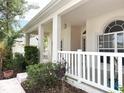 Inviting front porch with white pillars and decorative railing, creating a warm and welcoming entrance to the home at 3555 Chapel Hill Blvd, Clermont, FL 34711