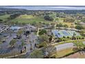 Community aerial showcasing the clubhouse, pool, tennis courts, and surrounding golf course at 4239 Fawn Meadows Cir, Clermont, FL 34711