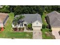 Attractive home with a well-maintained lawn, mature trees, and a paved driveway at 4239 Fawn Meadows Cir, Clermont, FL 34711