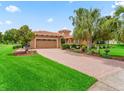 Charming home featuring a brick driveway, two-car garage, manicured lawn and mature landscaping at 5235 Island Terrace Ct, Lady Lake, FL 32159