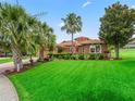 Inviting exterior showcasing lush lawn, mature trees, well-maintained landscaping, and paver driveway at 5235 Island Terrace Ct, Lady Lake, FL 32159
