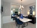 Elegant dining room featuring a modern chandelier, mirrored wall, and stylish decor at 5390 Marshelder St, Apopka, FL 32712