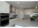 Modern kitchen with stainless steel appliances, granite countertops, and ample cabinet space at 5390 Marshelder St, Apopka, FL 32712
