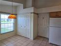 Cozy breakfast nook featuring tile flooring, a laundry closet, backyard views, and a unique vintage light fixture at 5436 Astor St, Leesburg, FL 34748