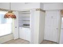 Functional laundry closet with stacked washer and dryer units, built-in shelving, and nearby kitchen at 5436 Astor St, Leesburg, FL 34748