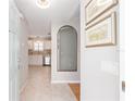 Inviting foyer with views of the kitchen featuring stainless appliances and neutral tile flooring at 579 Audrey Ln, The Villages, FL 32162