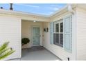 Welcoming front porch with light blue shutters and a decorative door, offering a cozy entrance at 579 Audrey Ln, The Villages, FL 32162