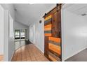 Hallway featuring rustic barn door leads to a living space with a pool view at 721 Mendoza Dr, Orlando, FL 32825