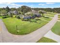 Expansive property with lush lawn, mature trees, and elegant single-story home with a long driveway at 7350 Spring Mountain Ln, Yalaha, FL 34797