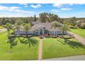 Beautiful single-story home with manicured lawn and walkway, palm trees, and inviting entrance at 7350 Spring Mountain Ln, Yalaha, FL 34797
