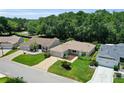 Aerial view of well-maintained homes featuring lush landscaping and patterned driveways in a quiet neighborhood at 8377 Se 177Th Bartram Loop, The Villages, FL 32162