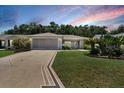Charming single-story home featuring a well-manicured lawn and a beautifully patterned driveway at 8377 Se 177Th Bartram Loop, The Villages, FL 32162
