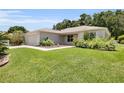Beautiful single-story home featuring lush green lawn, landscaping, and an attached two-car garage at 8377 Se 177Th Bartram Loop, The Villages, FL 32162