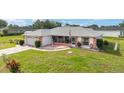 Charming single-story home with a cozy screened-in porch, a manicured lawn, and a decorative driveway at 8850 Se 156Th St, Summerfield, FL 34491