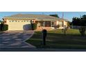 Lovely home featuring an attached garage, front screened-in porch, and a classic mailbox at 8850 Se 156Th St, Summerfield, FL 34491