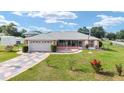 Inviting single-story home with a gray roof, decorative driveway, and a welcoming screened-in front porch at 8850 Se 156Th St, Summerfield, FL 34491