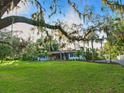 Beautifully landscaped property featuring a sprawling lawn, mature trees, and a view of the charming home at 9269 Silver Lake Dr, Leesburg, FL 34788