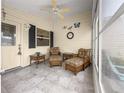 Comfortable enclosed porch featuring tile floors, ample seating, and decor at 992 Davit Pl, The Villages, FL 32162