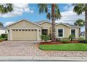 Charming single-story home with a brick driveway, well-manicured landscaping, and a two-car garage at 10046 Ketch Kay Ln, Oxford, FL 34484