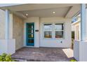 Inviting front porch with brick flooring, modern blue door, and bright natural lighting at 10302 Pearson Ave, Orlando, FL 32827