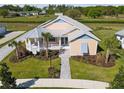 An elevated view showcases a charming single-story home with inviting porch and lush landscaping at 1042 Sugarloaf Key Loop, Lady Lake, FL 32159