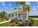 Beautifully landscaped home with palm trees, manicured shrubs, and a covered front porch at 1057 Sugarloaf Key Loop, Lady Lake, FL 32159
