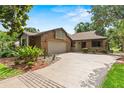 Attractive brick home with a two-car garage, landscaping and a wide driveway at 112 Waterwood Dr, Yalaha, FL 34797
