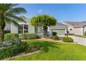 Charming single-story home with a well-manicured lawn, mature landscaping, and a two-car garage at 1122 Magrath Way, The Villages, FL 32162