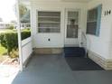 Inviting entrance featuring a covered patio, white picket fence, and well maintained landscaping at 114 Azalea Trl, Leesburg, FL 34748