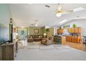 Open-concept living room featuring neutral tones, carpet, and a seamless flow to the kitchen at 1214 Loch Rannoch Ct, Leesburg, FL 34788