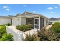 Charming single-story home featuring a screened lanai, white picket fence, and an attached one car garage at 1225 Eunice St, The Villages, FL 34762