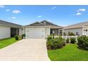 Attractive single-story home with a well-maintained lawn, picket fence, and a convenient attached garage at 1225 Eunice St, The Villages, FL 34762