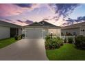 Inviting single-story home featuring a well-kept lawn, charming white picket fence, and attached garage at 1225 Eunice St, The Villages, FL 34762